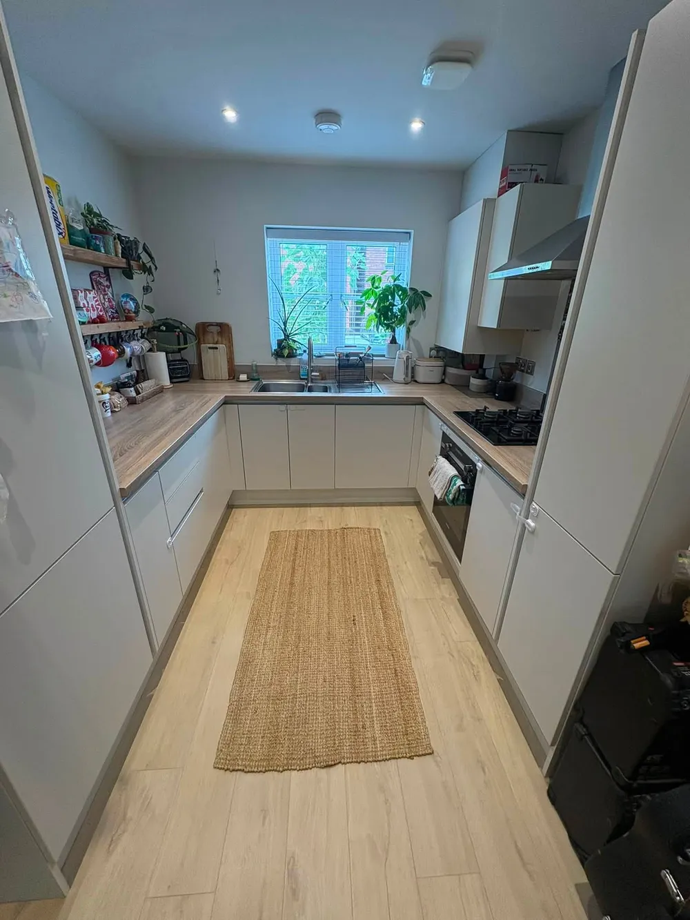 Same kitchen after cleaning, with clear worktops and mopped floor