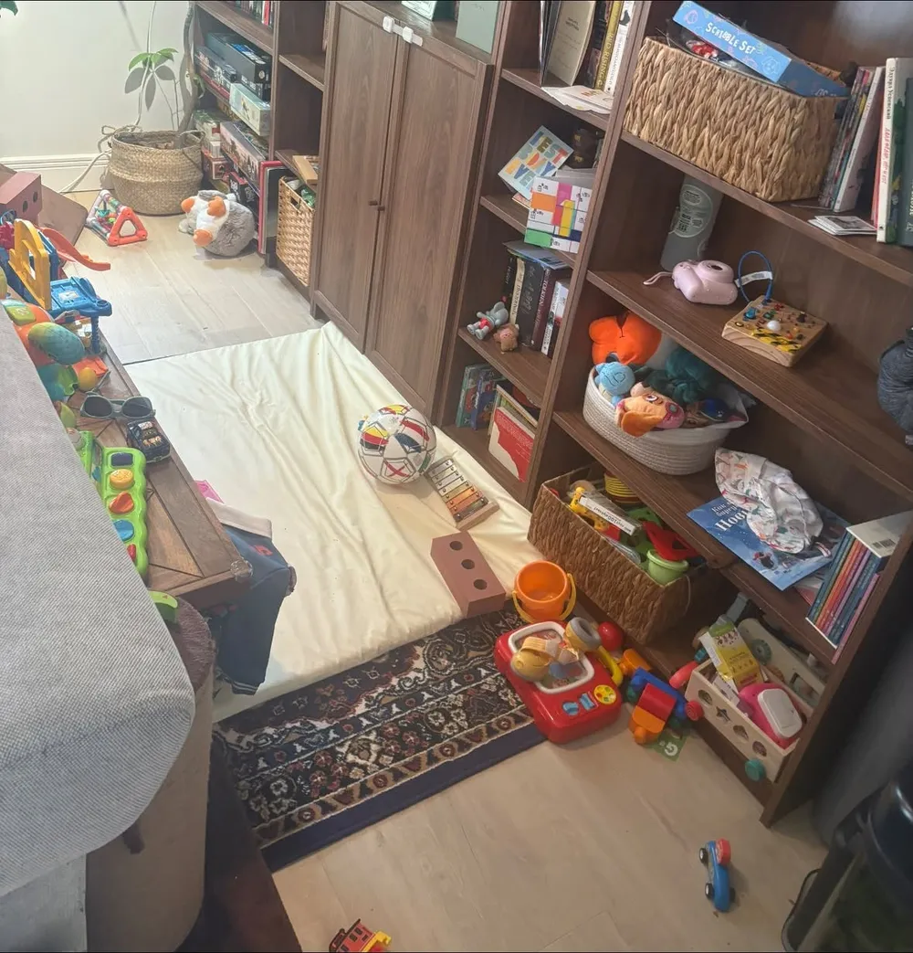 Playroom before cleaning, toys spread across the floor
