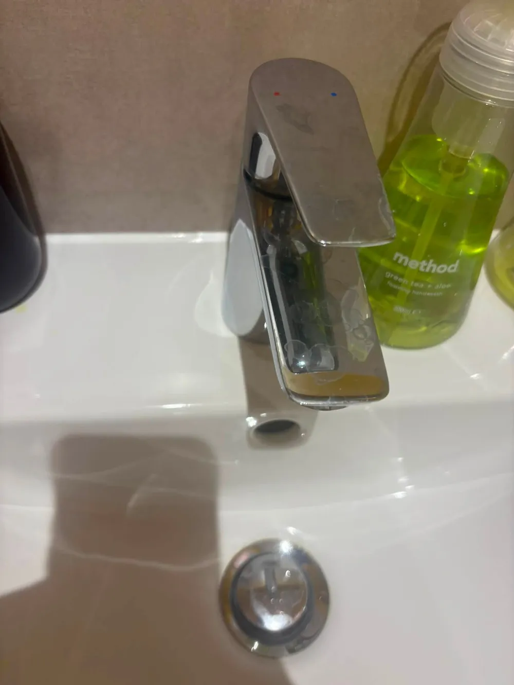 Bathroom tap before cleaning, showing water marks and residue